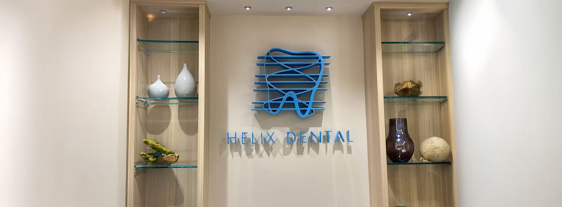 The image shows an interior space with a display case containing various objects, including vases and decorative items. Behind the display case, there is a sign with text and logos, indicating that this is likely a dental office named The Dental Spa.